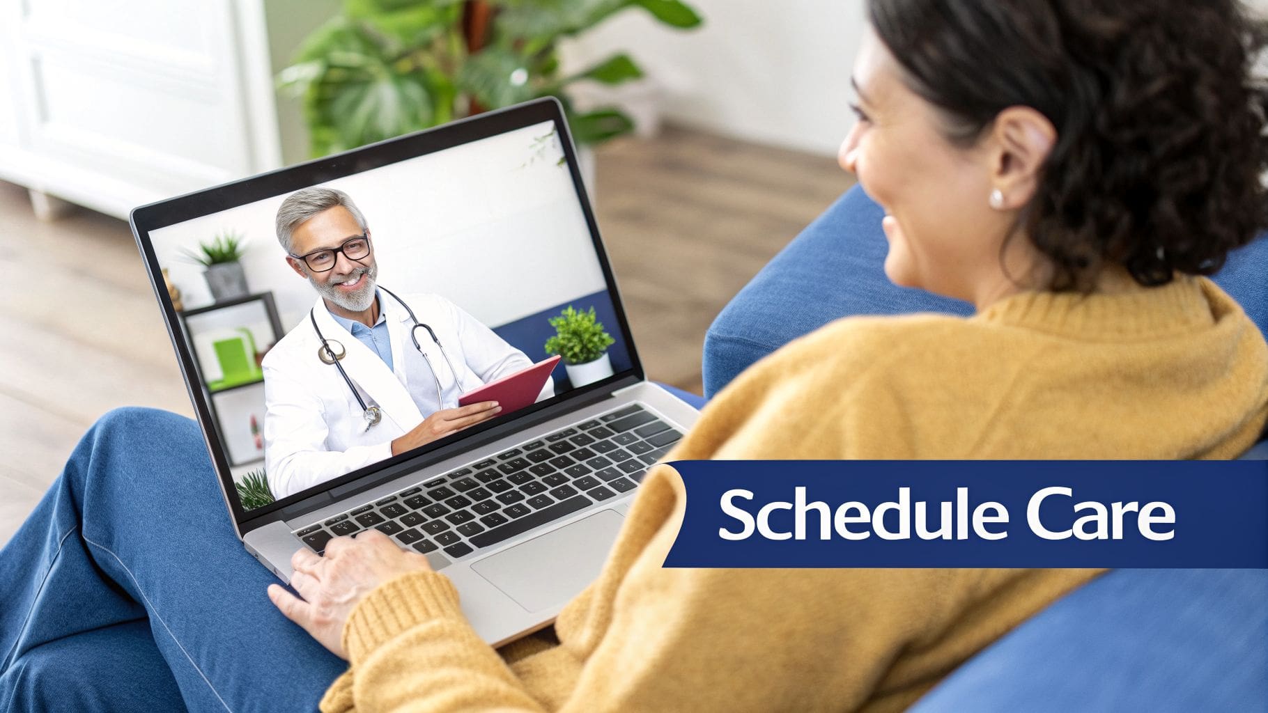 A woman smiles while having a virtual care appointment with a male doctor on her laptop.